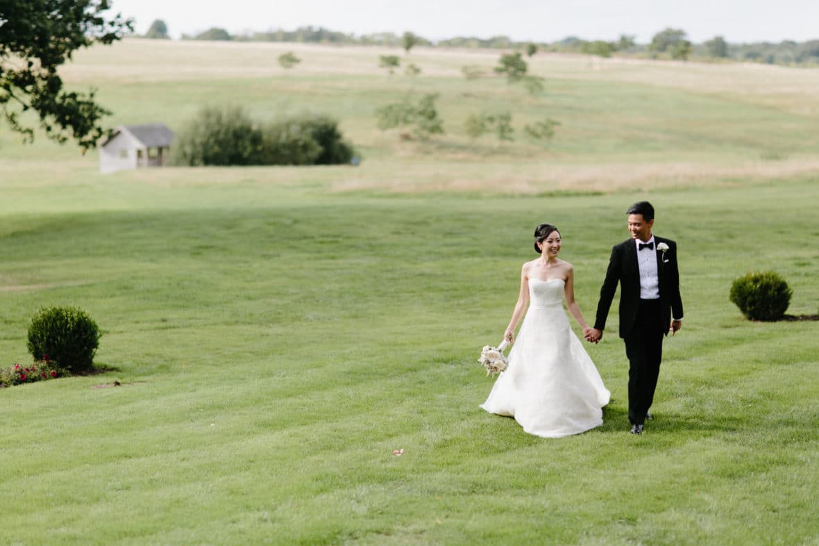 Bride and groom walking through the grounds of Four Seasons Hotel Hampshire on their wedding day