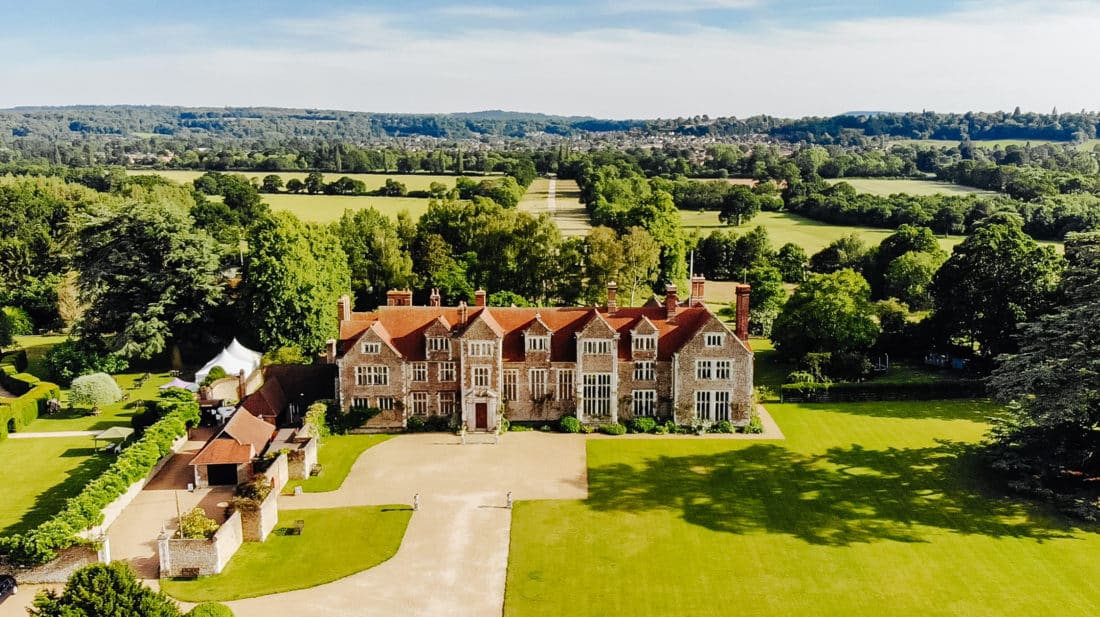 Bride and groom walking through the gardens of a romantic Surrey wedding venue