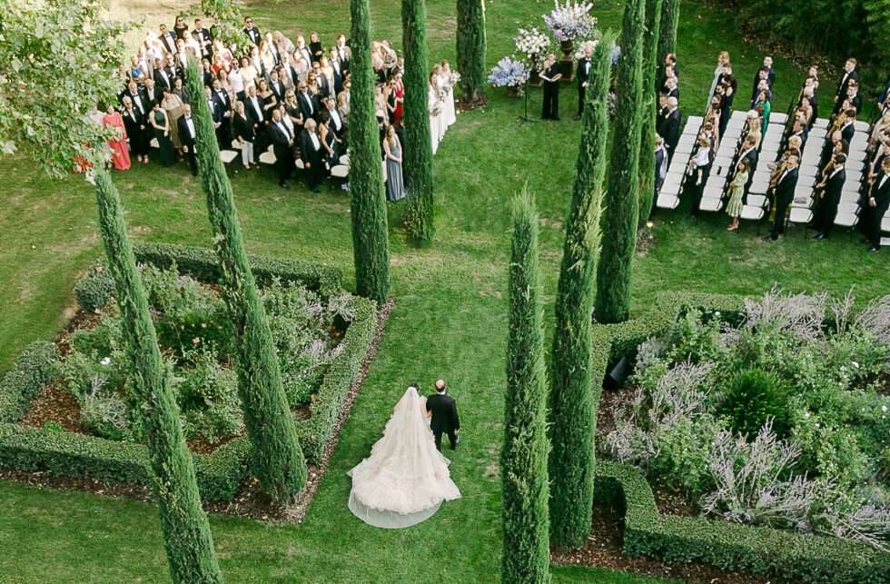 Aerial view of bride walking down the aisle at Le Mas de Poiriers garden wedding ceremony in Provence