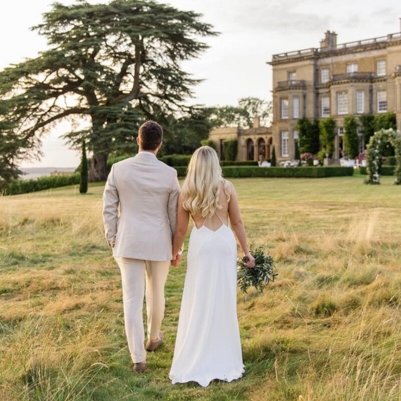 Bride walking through Hedsor House gardens – cinematic wedding photo in UK countryside venue